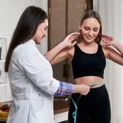 A clinician measuring a client’s waist