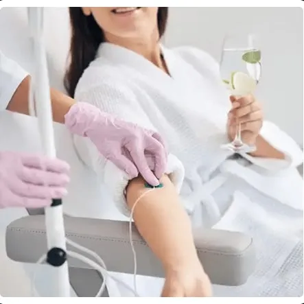 A clinician placing an IV line for a client holding a drink