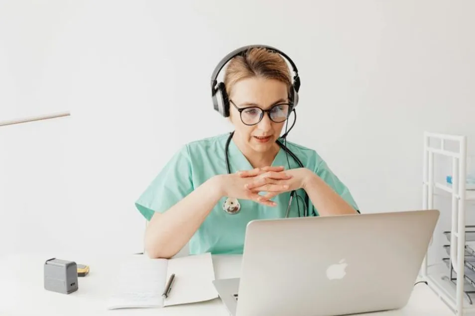 A nurse practitioner on a telehealth call at her laptop